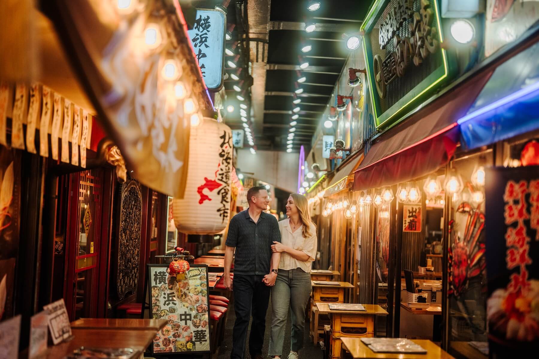 A couple walking through the streets of Tokyo, Japan on vacation on a couples photo shoot with Flytographer.